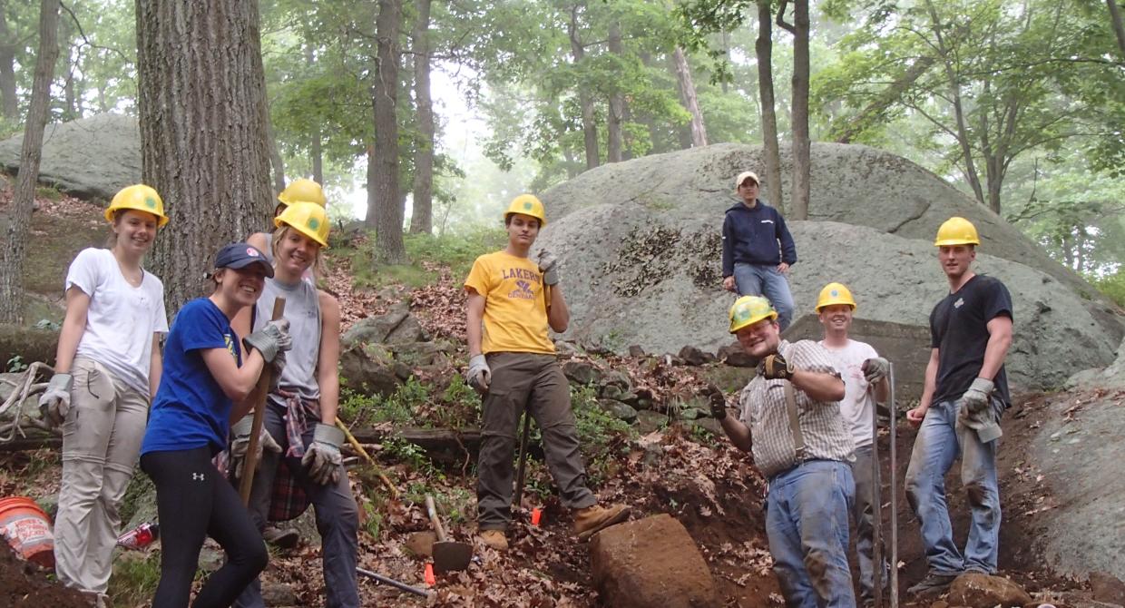 Volunteers excavate big rock from the trail.  