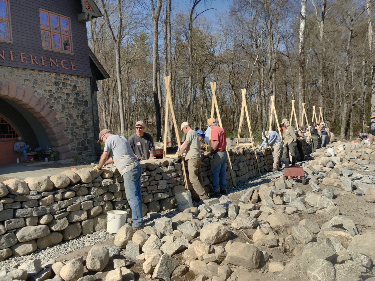 Participants in the first dry stone wall workshop at Trail Conference Headquarters cap the wall. Photo by Brian Post.